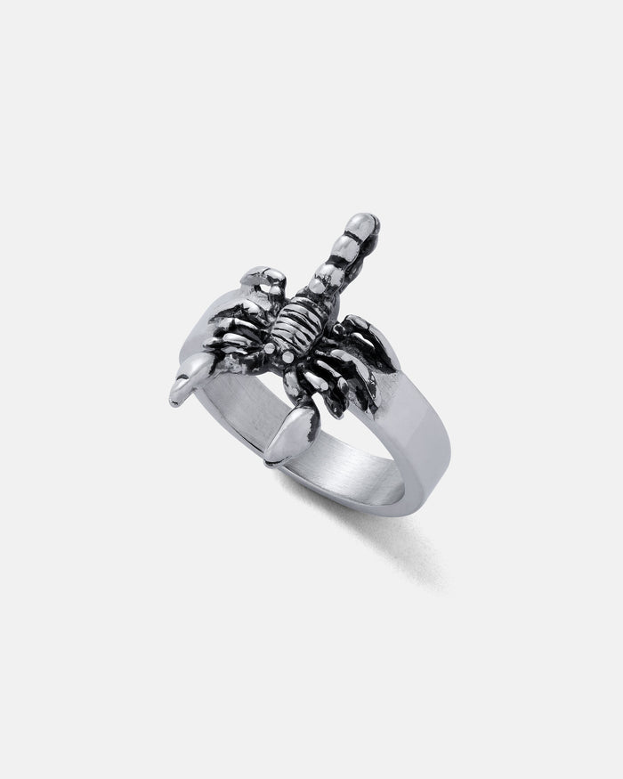 The Scorpion Ring, crafted in silver with a raised scorpion and arched tail over the band, is a bold piece of jewelry that stands out against a plain white background.