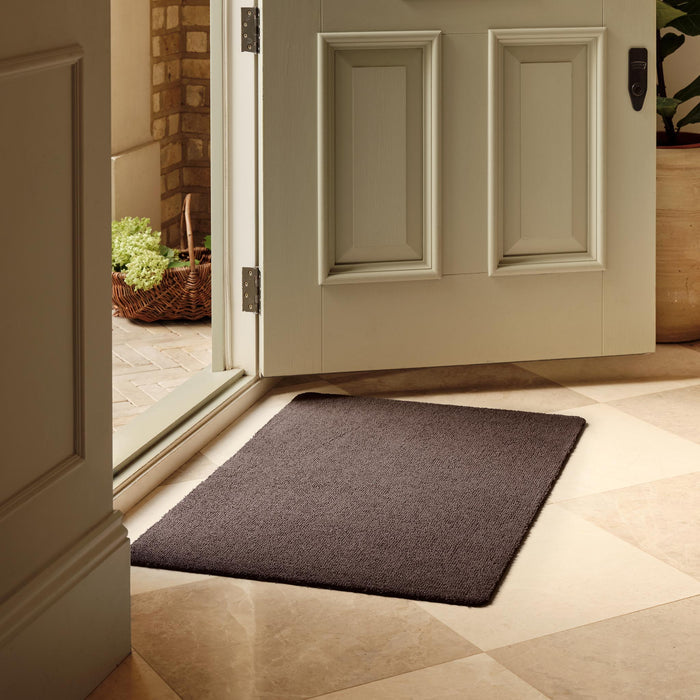 Sense Mink Washable Doormat in a solid brown colour, styled in a entryway.