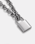 A close-up of the Statement Collective Statement Lock & Chain 2.0 silver necklace, showcasing its shiny padlock pendant—perfect statement jewelry displayed against a plain light background.