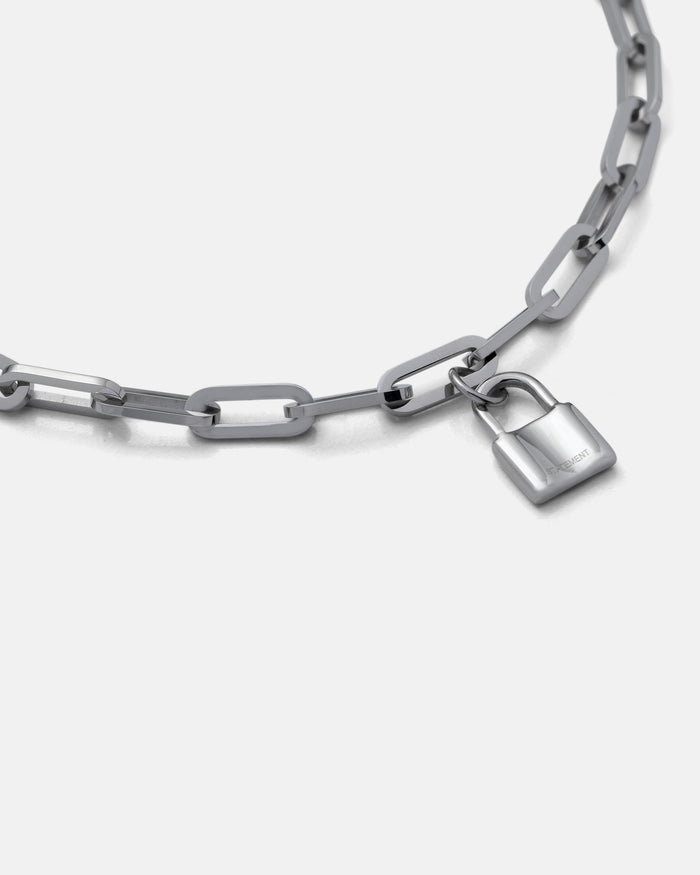 The Dainty Charm Choker (Custom Pendant Choice) is a silver paperclip chain necklace with large rectangular links and a small silver padlock charm, shown against a plain white background.