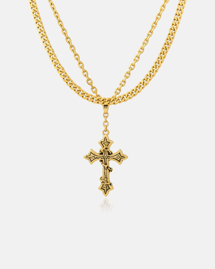 The Ruins" 6mm Set (Gold) necklace features a decorative gothic cross pendant with intricate details, elegantly displayed on a plain white background.