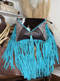 Western shoulder bag with a cowhide flap, turquoise tooled leather panels and long turquoise suede fringe