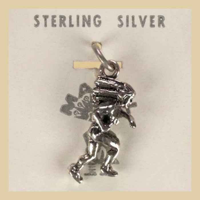 Vintage Maisel's Sterling Silver Dancer in Headdress Charm, New Old Stock, shown on a desert plaster background
