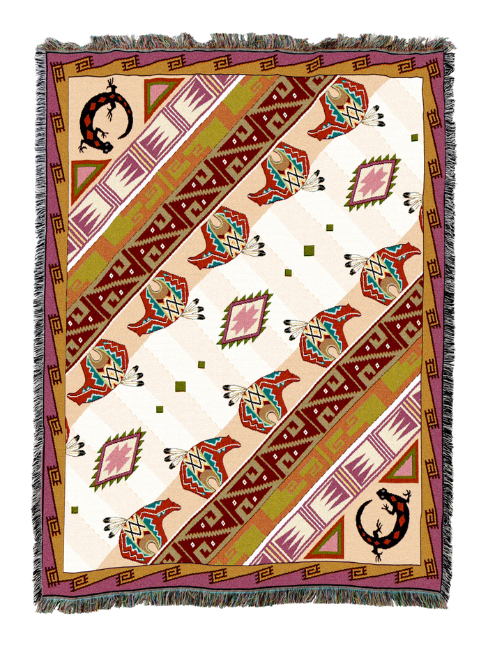 Western Slant cotton throw in the Bisque colorway, diagonal bands of aztec geometry in red, teal, olive and plum crossing a pale cream ground with horseshoe motifs in the corners