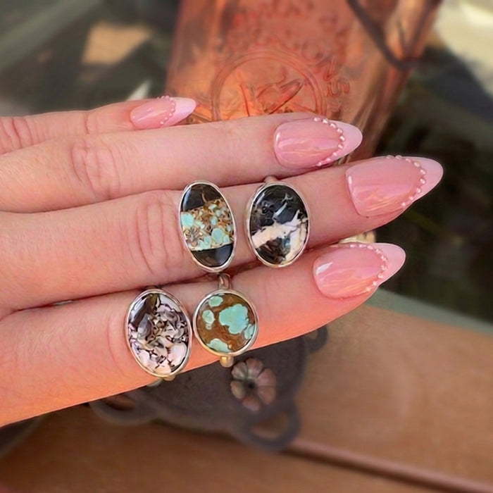 Wildflower Artisans sterling silver rings featuring oval Wild Horse and turquoise stones on a hand with pink nails